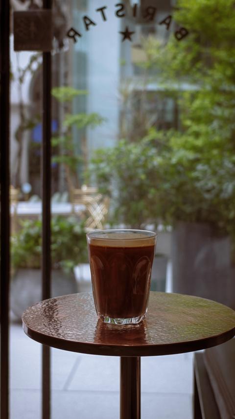Verre de café servi dans un bureau verdoyant, symbole du service café entreprise 24 h sans stress
